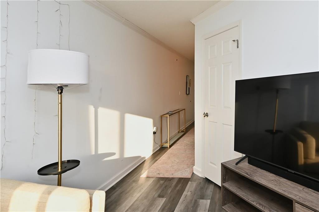 Hallway featuring dark hardwood / wood-style flooring and crown molding