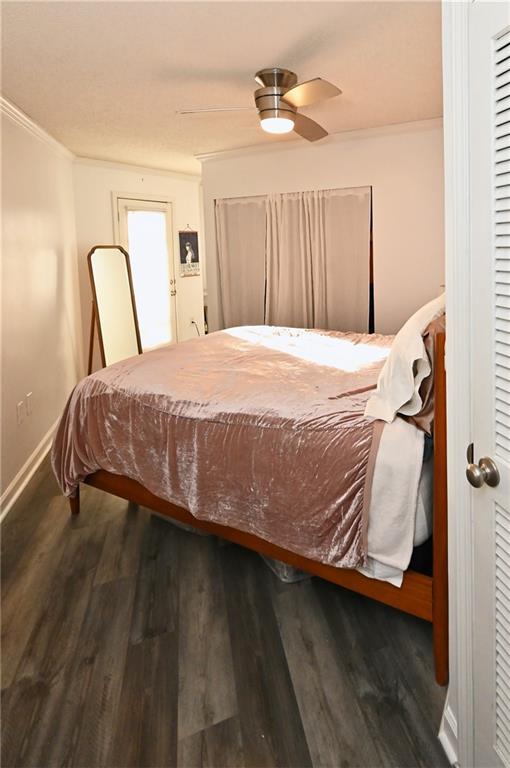 Bedroom featuring crown molding, ceiling fan, and dark wood-type flooring