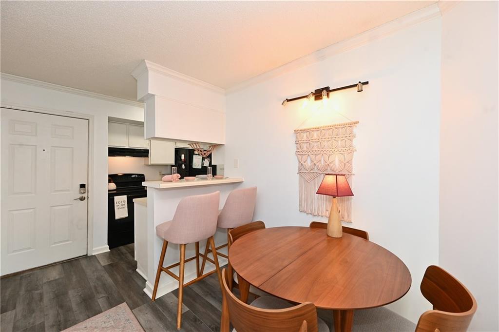 Dining room featuring dark wood-type flooring and ornamental molding