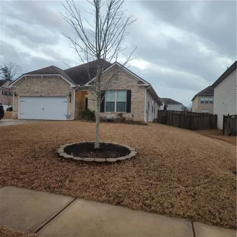 Single story home with brick siding, concrete driveway, and a garage