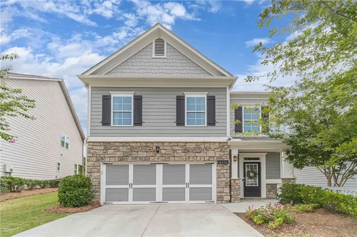 Contemporary two-story exterior featuring a stone facade and gray siding