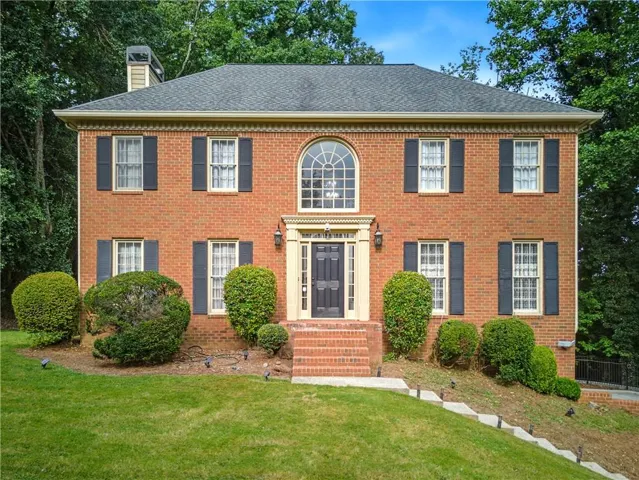 Brick exterior with a prominent arched window above the entry