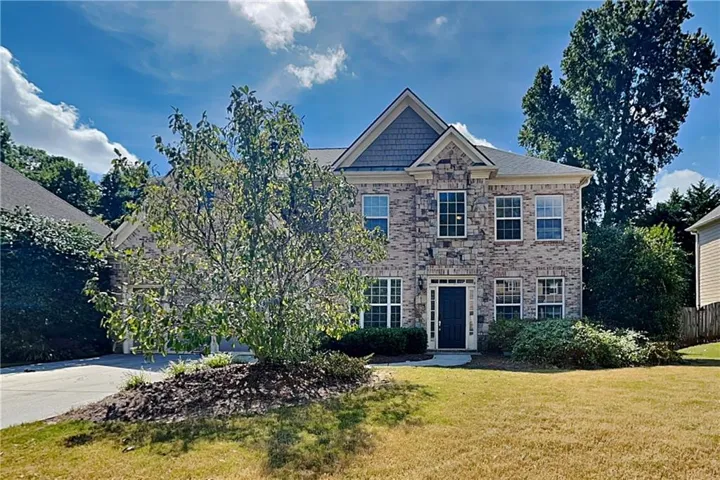 Stone-front exterior with multiple gables and a dark entry door