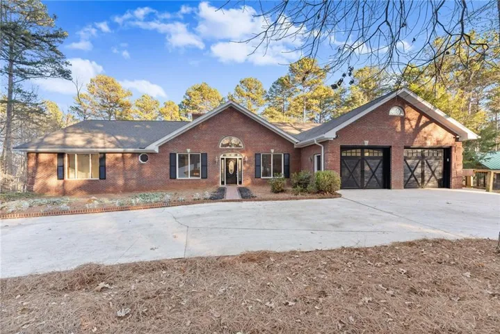 Brick exterior featuring a gabled roofline, decorative arched transom above the entry, and a covered porch