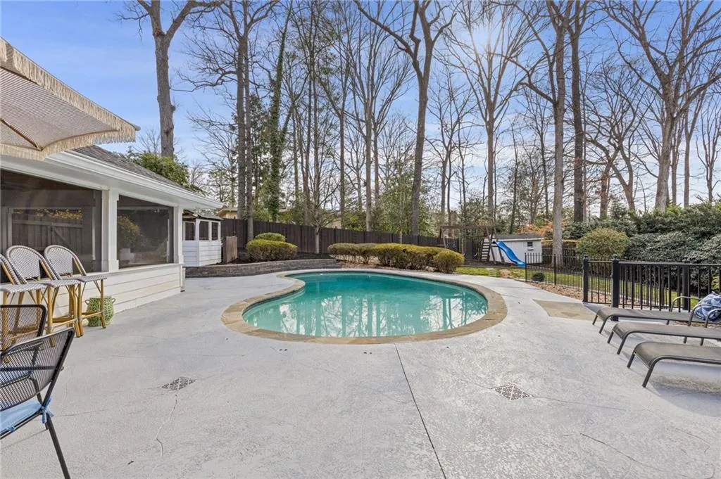View of pool featuring a fenced in pool, a playground, a fenced backyard, a sunroom, and a patio area