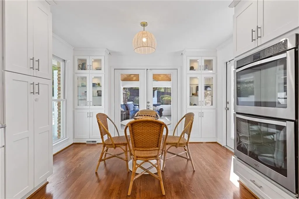 Dining space featuring crown molding, plenty of natural light, french doors, and wood finished floors