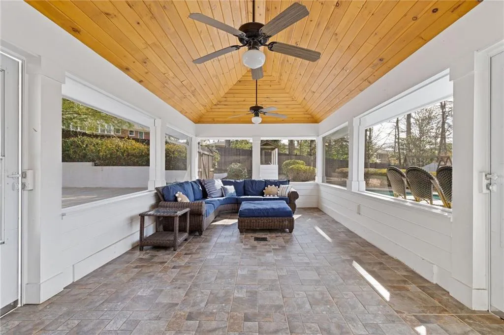 Sunroom / solarium featuring wood ceiling, ceiling fan, and vaulted ceiling