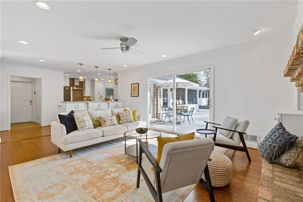 Living area with light wood finished floors, recessed lighting, crown molding, and a ceiling fan