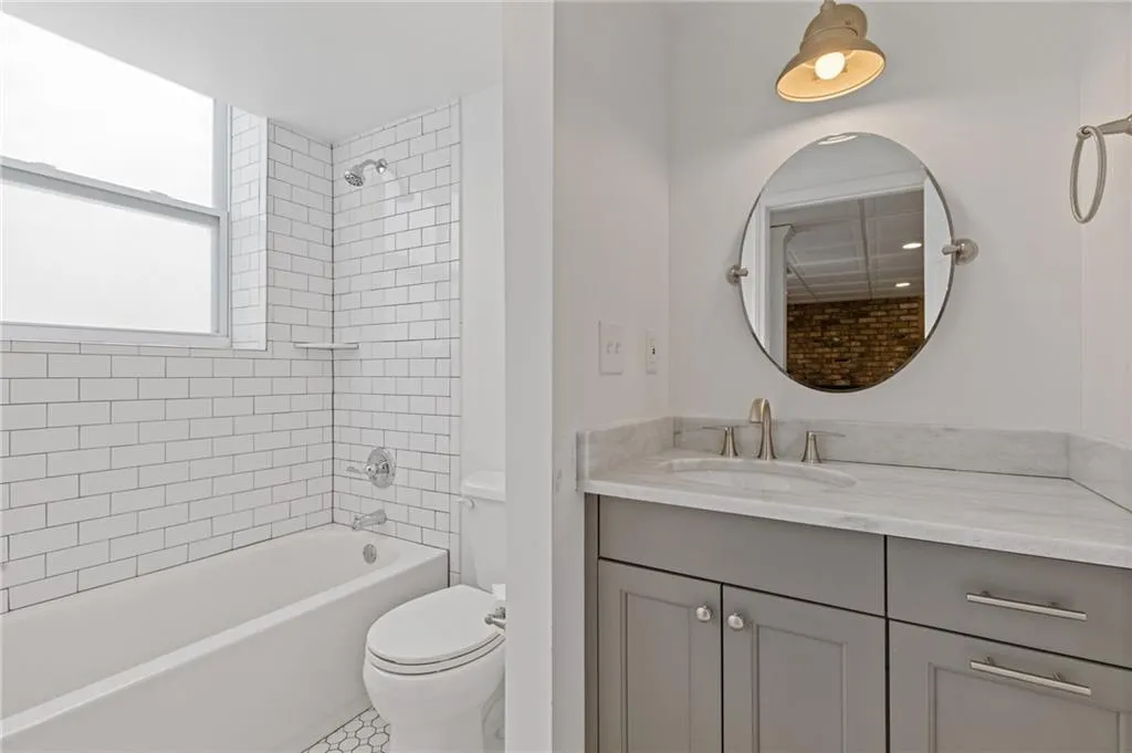 Bathroom featuring toilet,  shower combination, and vanity