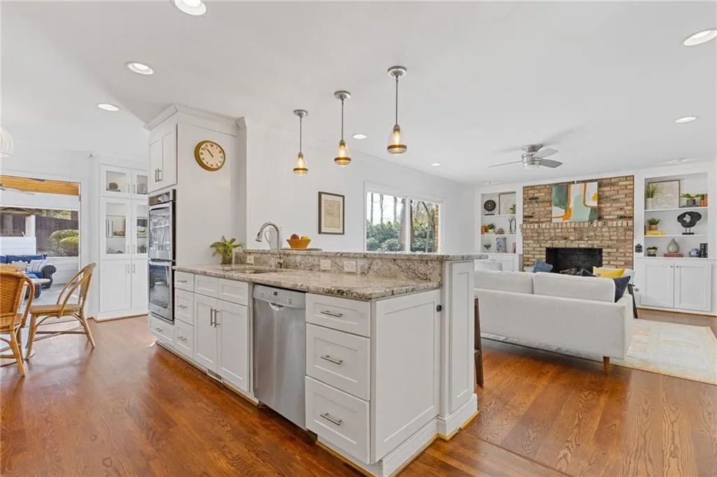 Kitchen with dark wood-style flooring, stainless steel appliances, ceiling fan, and a sink