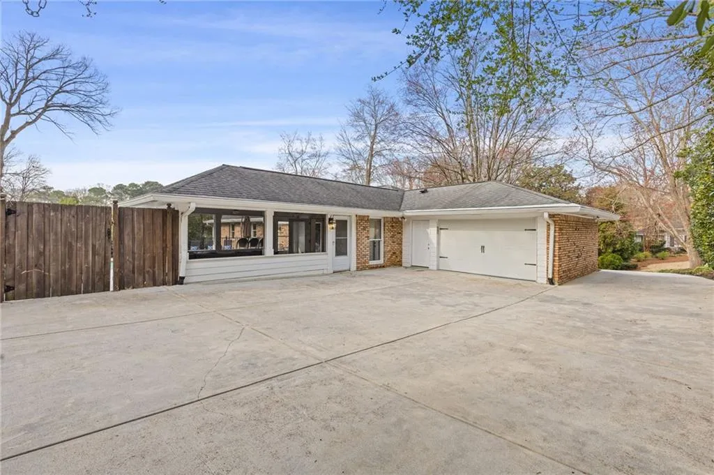 Single story home featuring fence, roof with shingles, concrete driveway, a garage, and brick siding