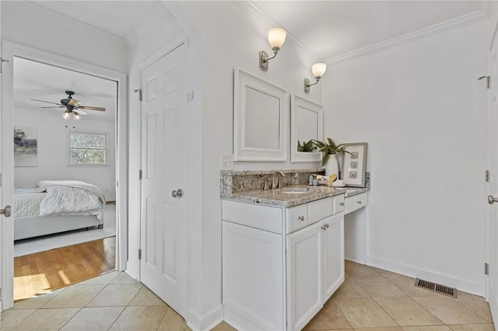 Bathroom featuring ceiling fan, tile patterned floors, visible vents, and ornamental molding