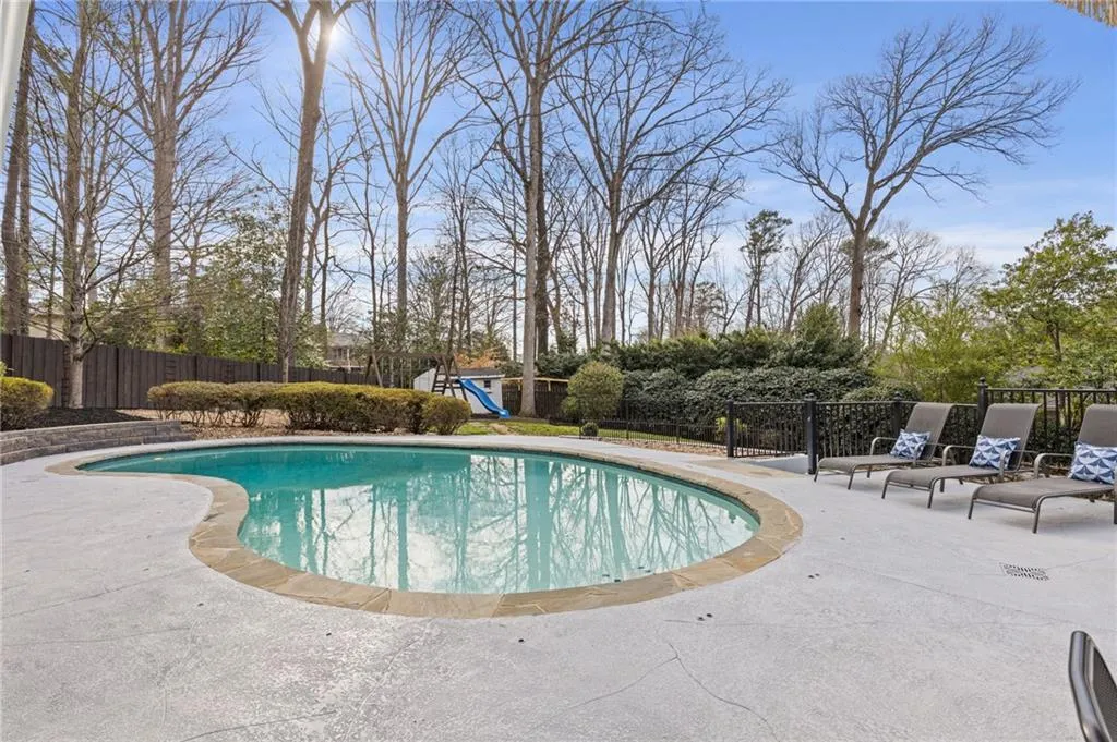 View of swimming pool featuring a patio area, a playground, fence, and a fenced in pool