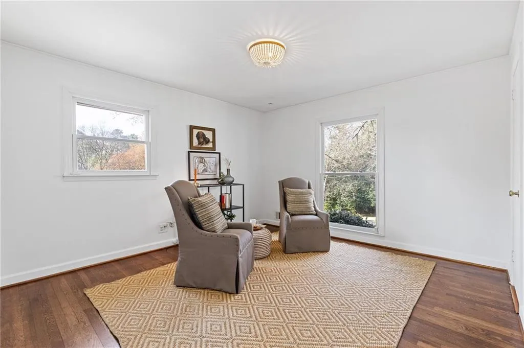 Living area featuring plenty of natural light, baseboards, and wood-type flooring