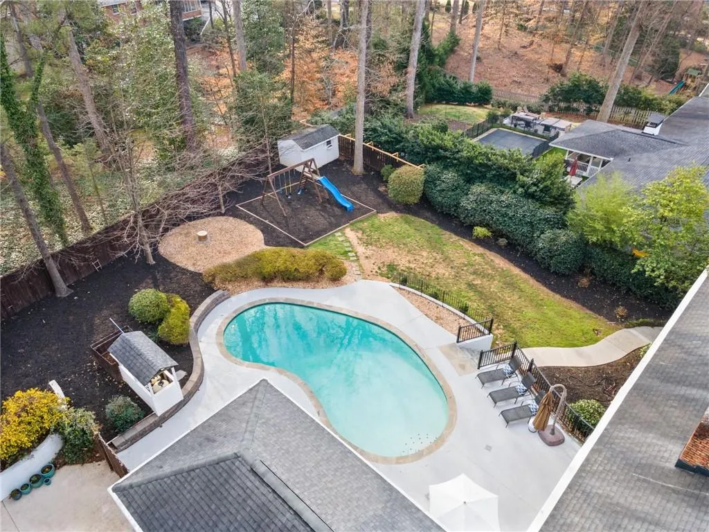 Outdoor pool with a playground and fence