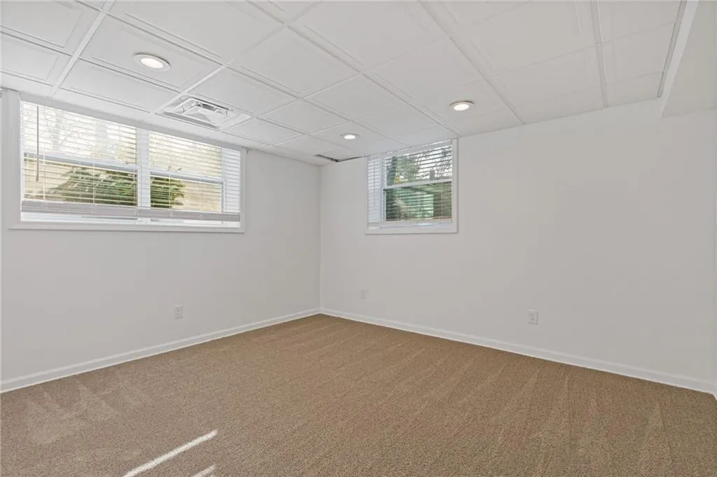 Empty room with recessed lighting, visible vents, baseboards, and carpet floors