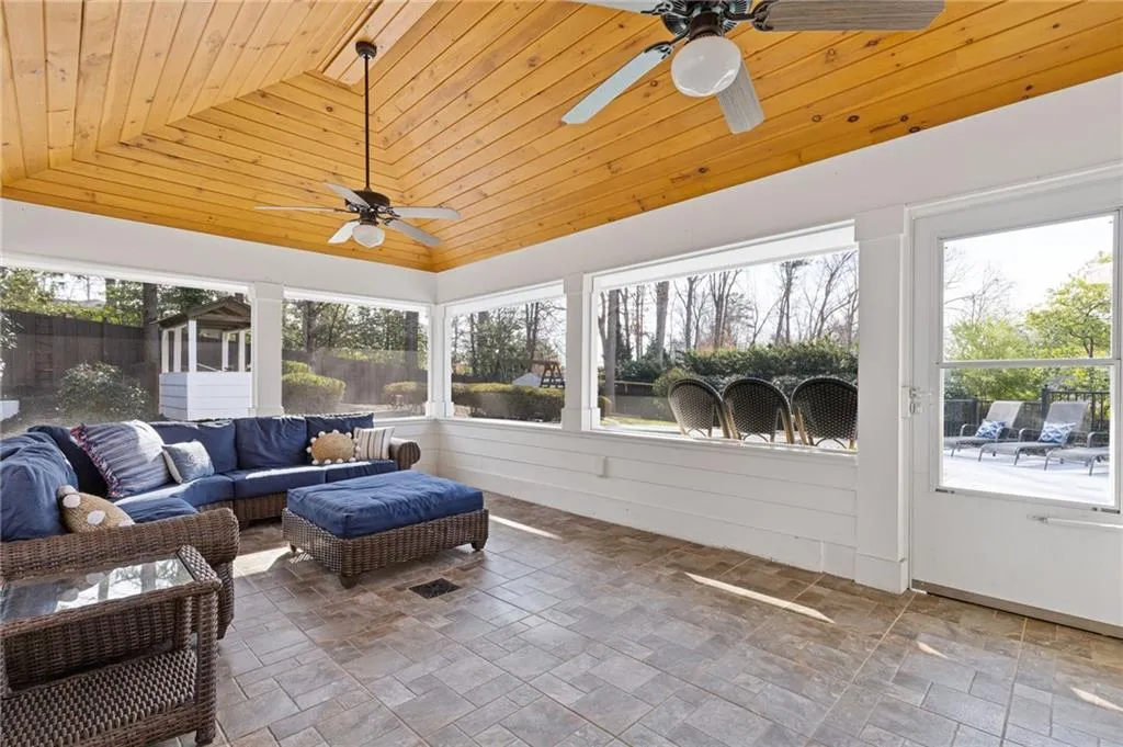 Sunroom / solarium with wood ceiling, a ceiling fan, and vaulted ceiling