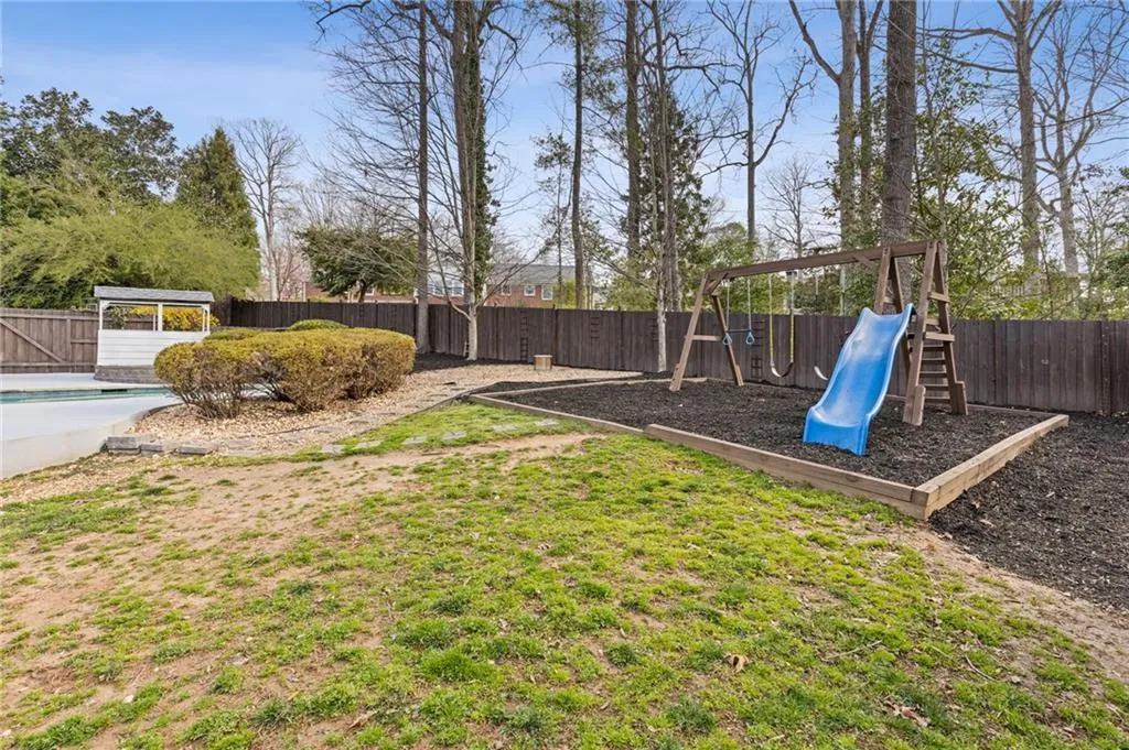 View of yard with a playground and a fenced backyard