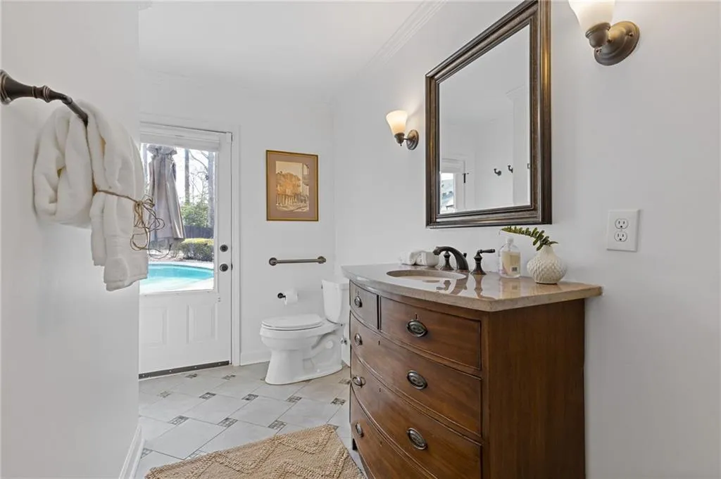 Bathroom with vanity, toilet, and ornamental molding