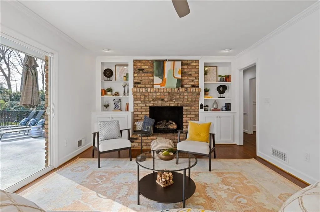 Sitting room with visible vents, crown molding, and wood finished floors