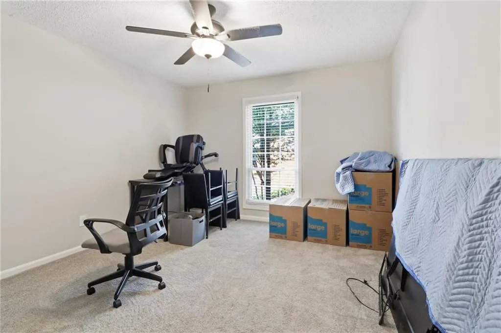 Carpeted room featuring a ceiling fan with integrated lighting, a single window with horizontal blinds, and neutral wall paint