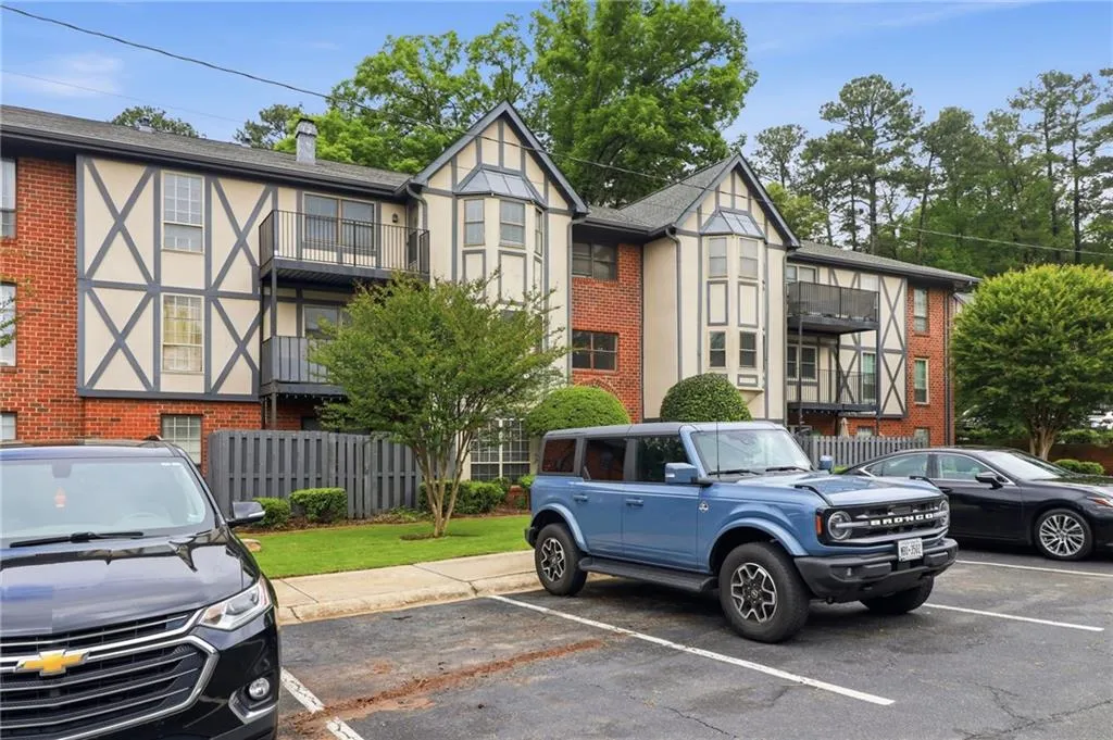 Tudor-inspired multi-story building featuring brick and stucco siding with dark timber-like detailing