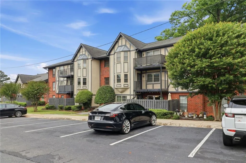 Tudor-style building exterior featuring brick and light-colored siding with dark trim accents