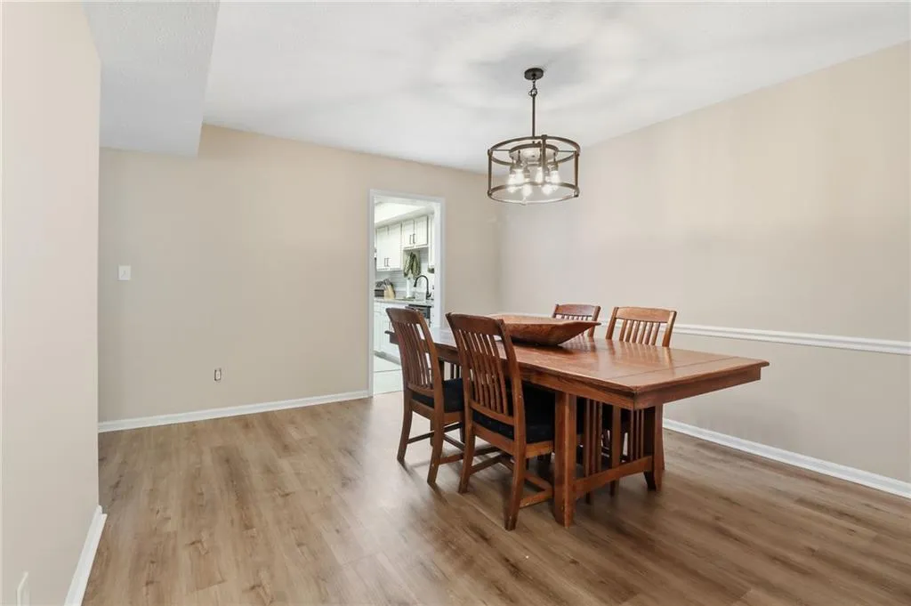 Dining area featuring wood-finish flooring, neutral wall paint, and a decorative drum chandelier