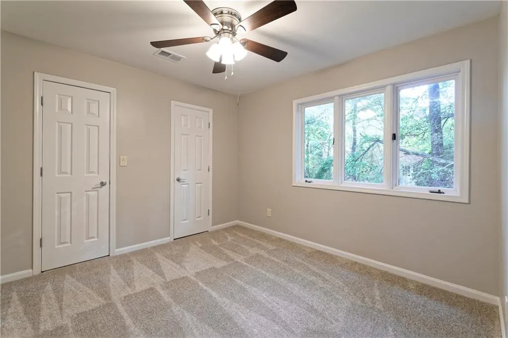 Unfurnished bedroom featuring baseboards, light carpet, and ceiling fan