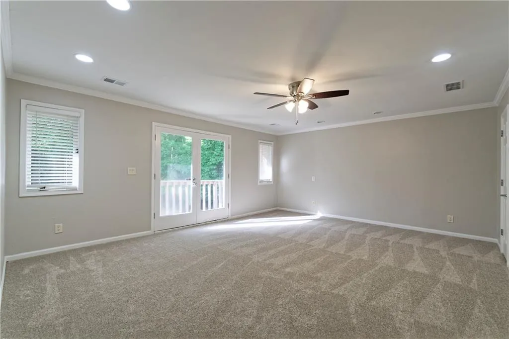 Unfurnished room featuring ceiling fan, light carpet, baseboards, healthy amount of natural light, and recessed lighting