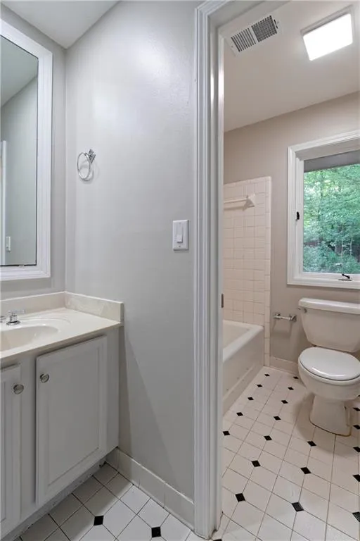 Full bathroom featuring tile patterned flooring, toilet, vanity, and baseboards