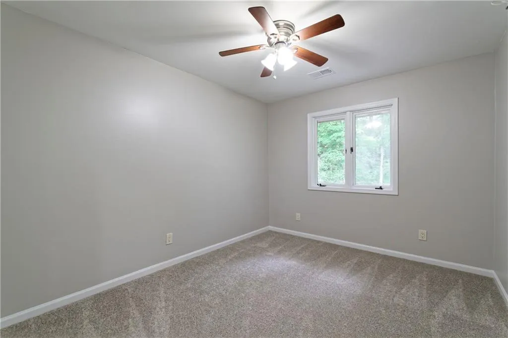 Unfurnished room with carpet flooring, baseboards, and a ceiling fan