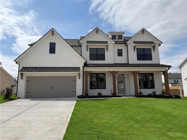 Contemporary white brick exterior featuring black-framed windows and a two-car garage