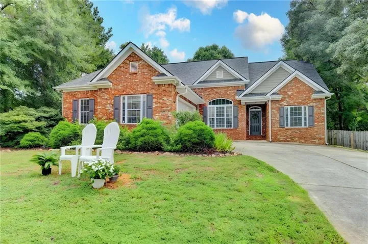 Brick exterior featuring gray shutters, an arched window, and multiple gables