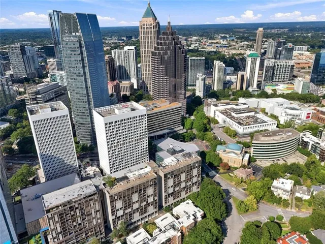 Aerial perspective showcasing a vibrant urban environment with numerous high-rise buildings and surrounding green spaces