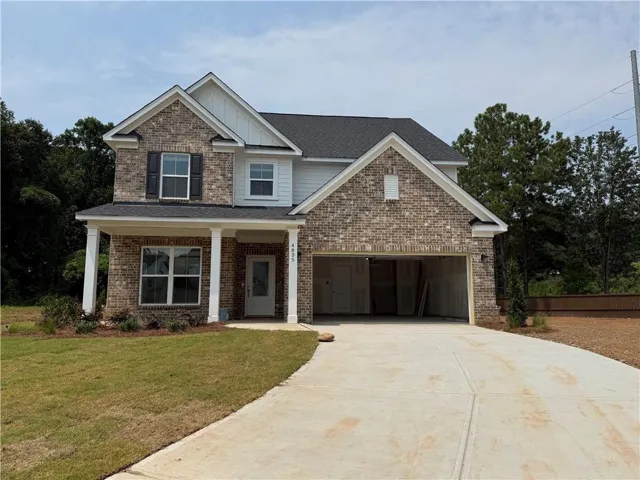 Brick and siding exterior with a covered porch, two-car garage, and a concrete driveway