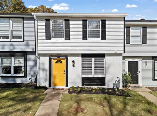 Townhome / multi-family property with a front lawn