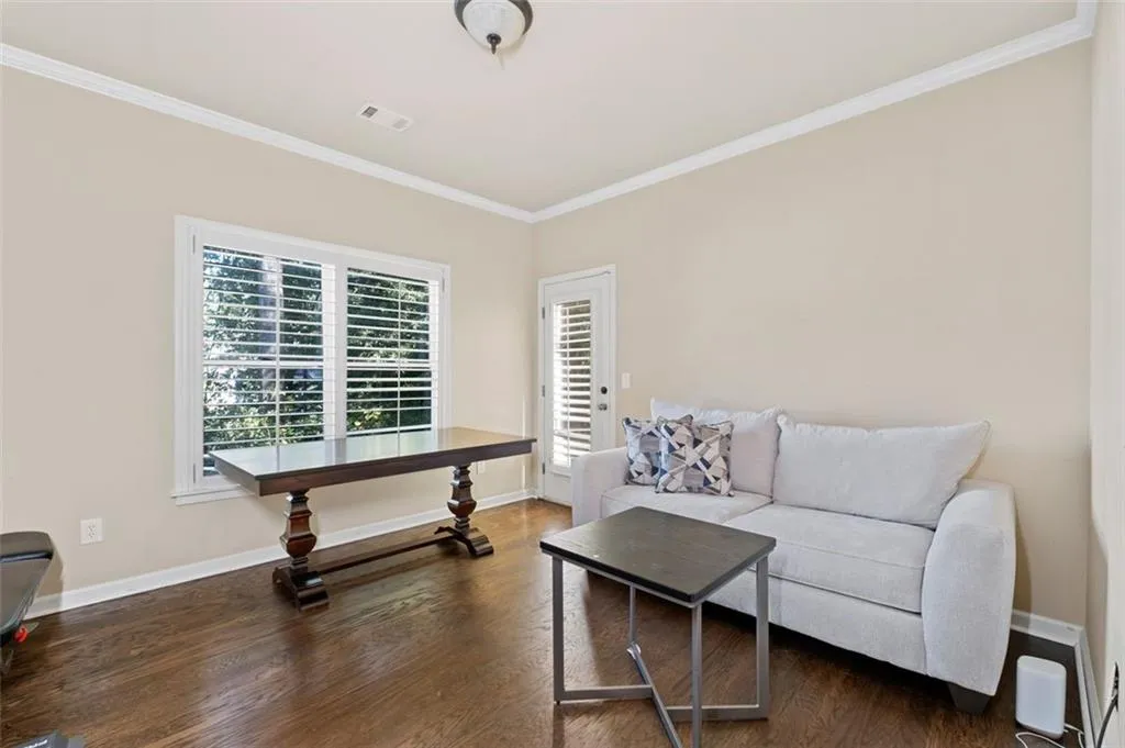 Living area with crown molding and wood finished floors