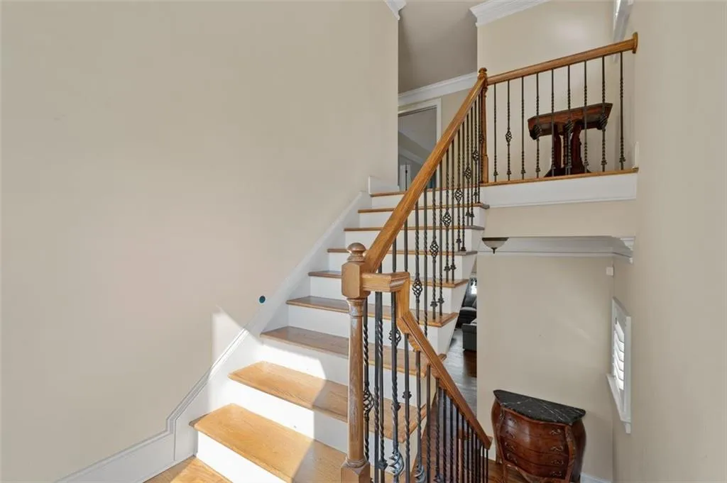 Stairway with baseboards and crown molding