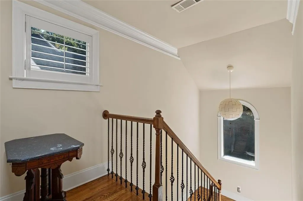 Stairway featuring plenty of natural light, ornamental molding, and wood finished floors