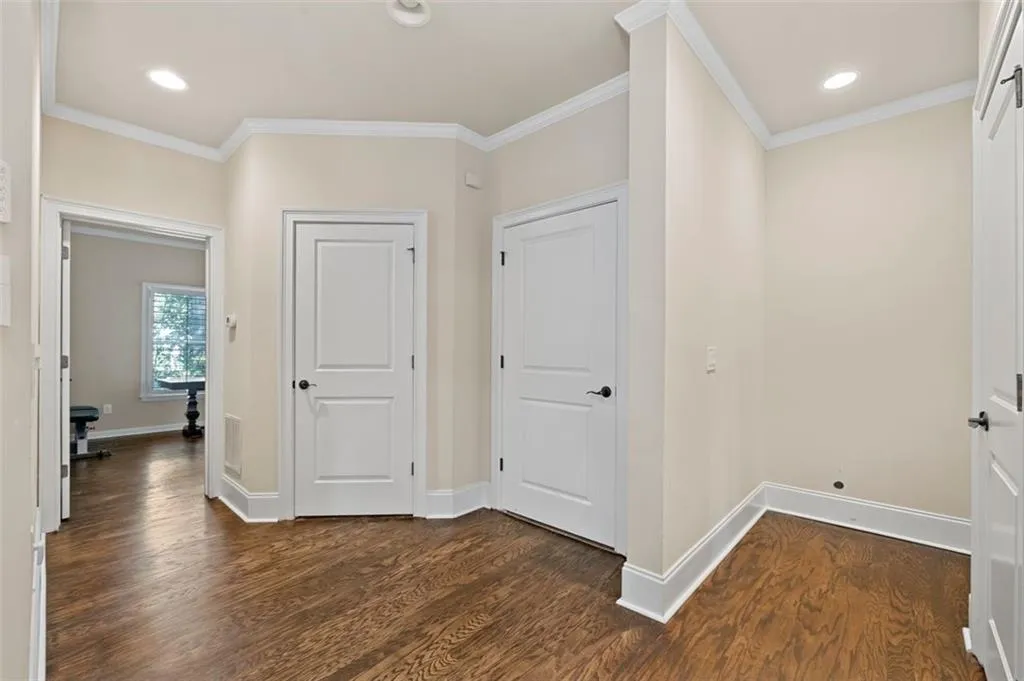 Hallway featuring recessed lighting, dark wood-style floors, and ornamental molding