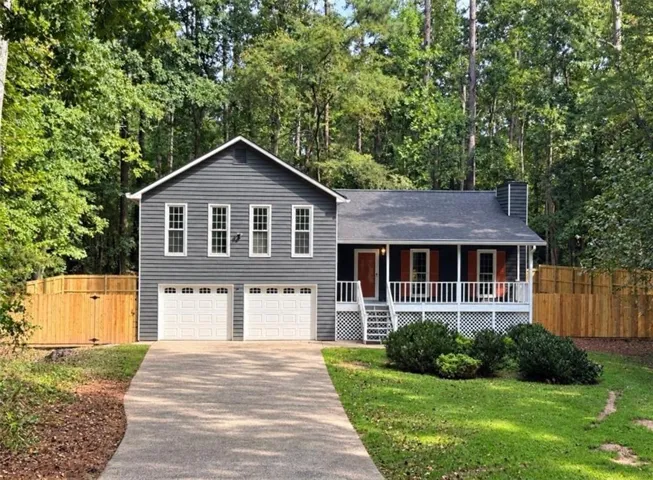 Gray siding exterior with white trim, a covered front porch, and a two-car garage
