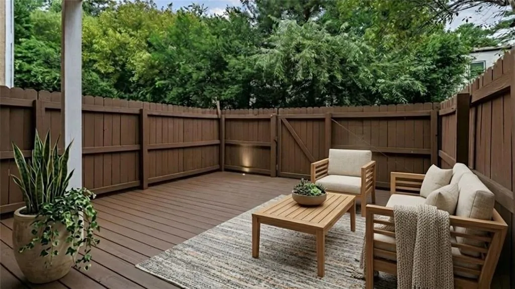 Wooden terrace featuring an outdoor lounge area and a fenced backyard