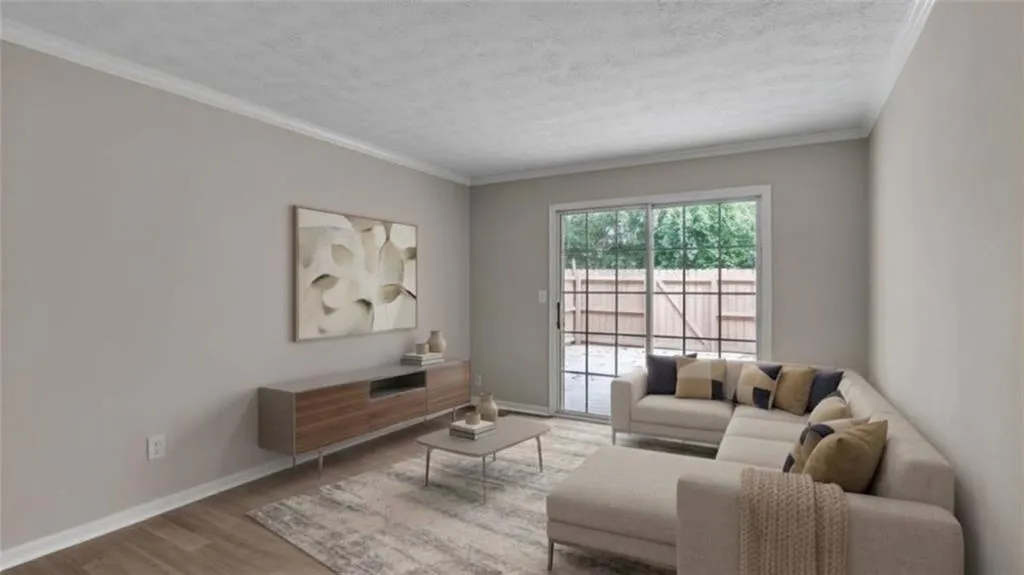 Living area featuring ornamental molding, wood finished floors, and a textured ceiling