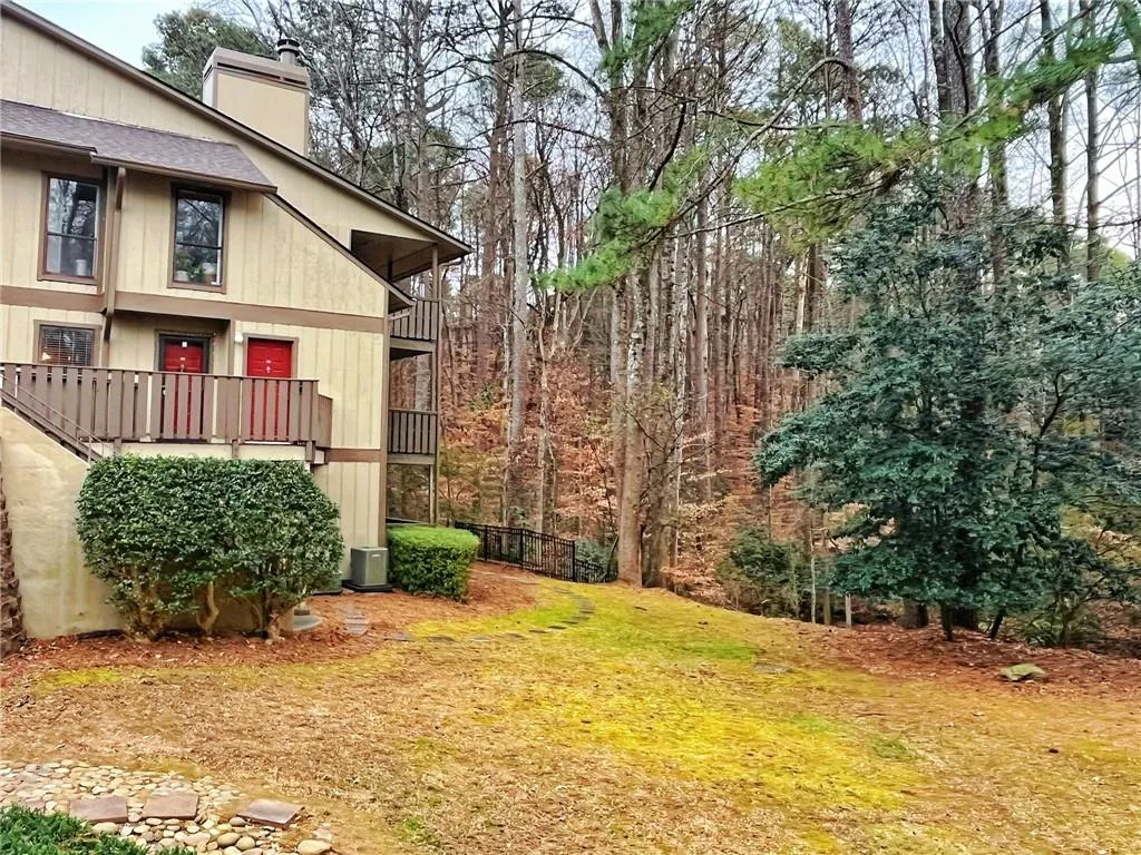View of yard with a balcony and a forest view