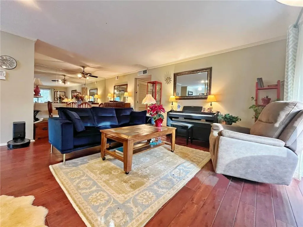 Living area featuring crown molding, hardwood / wood-style flooring, and ceiling fan