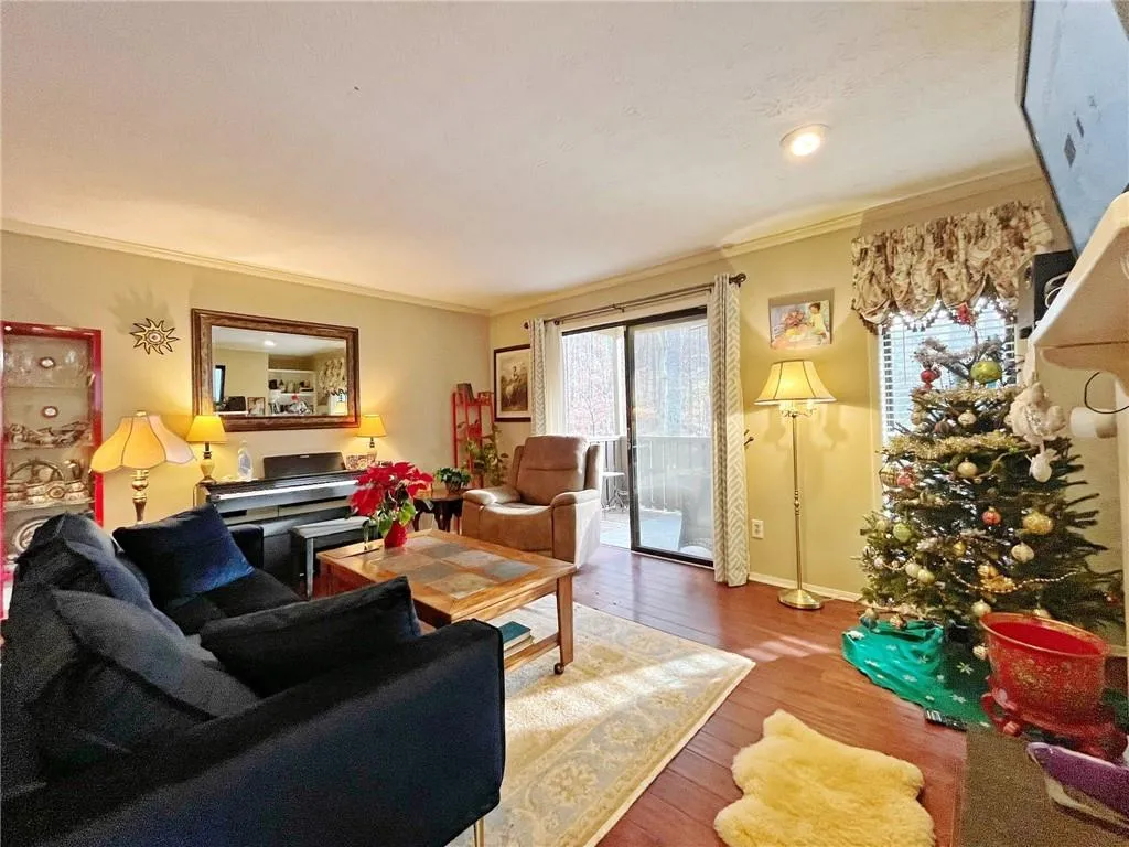 Living room featuring ornamental molding and wood-type flooring