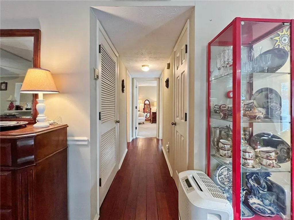 Hallway with dark wood-style flooring and baseboards