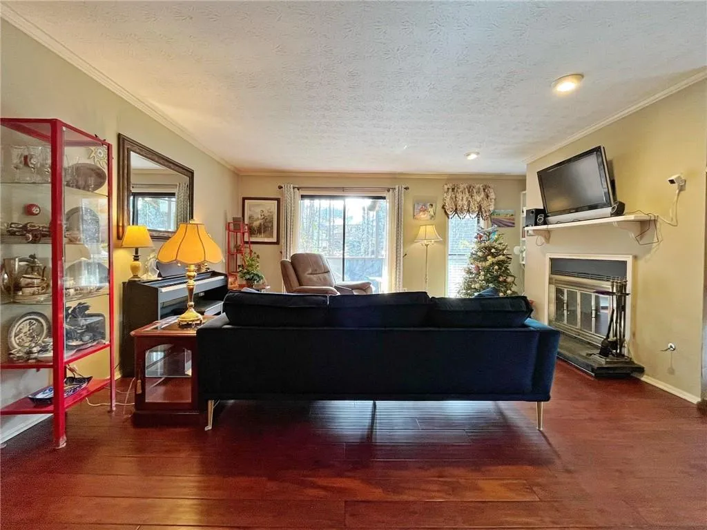 Dining area with a glass covered fireplace, crown molding, a ceiling fan, and a textured ceiling