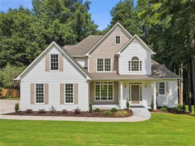 Two-story residence featuring white siding and tan accents